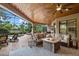 Inviting covered patio with a fire pit table, comfortable seating, and an outdoor kitchen area at 7628 Haddington Cv, Lakewood Ranch, FL 34202