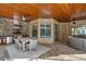 Spacious outdoor patio featuring a full kitchen, dining area, and comfortable seating under a wood-paneled ceiling at 7628 Haddington Cv, Lakewood Ranch, FL 34202