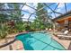 Screened-in pool with brick pavers, spa, chairs, and outdoor dining area at 7628 Haddington Cv, Lakewood Ranch, FL 34202