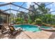 Sparkling screened pool and spa surrounded by lush landscaping, offering a private backyard retreat at 7628 Haddington Cv, Lakewood Ranch, FL 34202