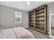 Bright bedroom featuring a large bookcase, a window, and a comfortable bed, ideal for relaxation at 8209 Redonda Loop, Lakewood Ranch, FL 34202