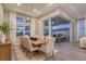 Elegant dining room featuring a large wood table, comfortable seating, and sliding glass doors to outdoor kitchen at 8209 Redonda Loop, Lakewood Ranch, FL 34202