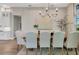 Dining room showcases a rustic wooden table and stylish lighting, adjacent to the modern kitchen at 8209 Redonda Loop, Lakewood Ranch, FL 34202