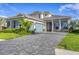 Beautifully landscaped two-story home featuring a blue garage door and brick-paved driveway at 8209 Redonda Loop, Lakewood Ranch, FL 34202