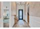 Elegant foyer features a decorative table, rug, chandelier, stylish door and hardwood floors at 8209 Redonda Loop, Lakewood Ranch, FL 34202