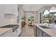 A stylish kitchen features white cabinets, stainless steel appliances, and a view into the dining area at 8209 Redonda Loop, Lakewood Ranch, FL 34202