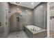 Sleek main bathroom featuring a modern soaking tub, a walk-in shower, and stylish gray tile at 8209 Redonda Loop, Lakewood Ranch, FL 34202