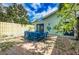 Inviting backyard patio area featuring a blue outdoor dining set and lush landscaping at 8709 9Th Nw Ave, Bradenton, FL 34209