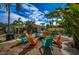 Cozy backyard fire pit area with colorful Adirondack chairs and lush tropical foliage at 8709 9Th Nw Ave, Bradenton, FL 34209