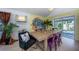 Dining room with wooden table, yellow accent wall with art, and a decorative light fixture at 8709 9Th Nw Ave, Bradenton, FL 34209