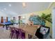 Dining room with yellow accent wall with art, a wooden table, and a view into game room at 8709 9Th Nw Ave, Bradenton, FL 34209