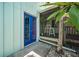 Charming beach home entrance with vibrant blue door and tropical landscaping at 8709 9Th Nw Ave, Bradenton, FL 34209