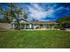 Charming single-story home with a lush green lawn, inviting front porch, and a bright yellow front door at 8709 9Th Nw Ave, Bradenton, FL 34209