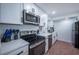 Updated kitchen features stainless steel appliances, white cabinets, and solid surface countertops at 8709 9Th Nw Ave, Bradenton, FL 34209