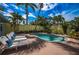 Private backyard oasis with a sparkling pool, sun loungers, tropical plants, and a privacy fence at 8709 9Th Nw Ave, Bradenton, FL 34209