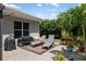 Paver patio features a grill, two lounge chairs on an area rug, and beautiful landscaping at 8840 Brookfield Ter, Bradenton, FL 34212