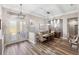 Open-concept dining room featuring stylish wood flooring, a large dining table, and contemporary lighting at 8840 Brookfield Ter, Bradenton, FL 34212