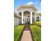 Inviting entryway featuring white columns, lush landscaping, and a brick path leading to the front door at 8840 Brookfield Ter, Bradenton, FL 34212
