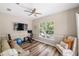 This home exercise room features wood floors, ceiling fan, tv and large window at 8840 Brookfield Ter, Bradenton, FL 34212