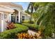 Charming home exterior featuring lush landscaping, a brick walkway, and an inviting entryway at 8840 Brookfield Ter, Bradenton, FL 34212