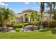 Beautiful exterior view of the home showcasing a well-manicured lawn, mature palm trees, and inviting landscaping at 8840 Brookfield Ter, Bradenton, FL 34212