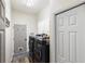 Modern laundry room with front load washer/dryer, gray door with pet door and wood look flooring at 8840 Brookfield Ter, Bradenton, FL 34212