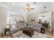 Open-concept living space with a large sectional, wood-look floors, and view of the kitchen at 8840 Brookfield Ter, Bradenton, FL 34212