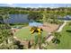 Aerial view of a community playground with lush landscaping, picnic tables, and lake views at 8840 Brookfield Ter, Bradenton, FL 34212
