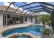 A lovely pool features an attached spa, travertine decking, and seamless indoor/outdoor living space at 8840 Brookfield Ter, Bradenton, FL 34212