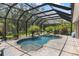 A screened pool area that includes a pool, spa, brick pavers, and lush landscaping at 8840 Brookfield Ter, Bradenton, FL 34212