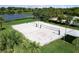 Aerial view of sand volleyball courts next to a lake and lush landscaping for outdoor recreation and community amenities at 8840 Brookfield Ter, Bradenton, FL 34212