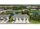 Overhead view of townhomes featuring attached garages, meticulously maintained lawns, and a scenic pond with fountain at 8979 Milestone Dr, Sarasota, FL 34238
