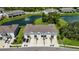 Overhead view of townhomes showcasing attached garages, well-kept lawns, and a charming pond complete with a fountain at 8979 Milestone Dr, Sarasota, FL 34238