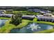 Backyard view of townhome on the pond with a water fountain, green grass, and view of the community pool at 8979 Milestone Dr, Sarasota, FL 34238