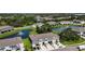 Overhead view of townhomes with attached garages, manicured lawns, and a picturesque pond with a fountain feature at 8979 Milestone Dr, Sarasota, FL 34238