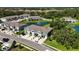 Overhead view of townhomes boasting garages, beautiful lawns, and a tranquil pond with a lovely water fountain at 8979 Milestone Dr, Sarasota, FL 34238