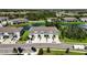 Overhead view highlighting townhomes with garages, lush lawns, and a peaceful pond featuring a striking fountain at 8979 Milestone Dr, Sarasota, FL 34238