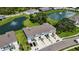 Aerial view showcases townhomes, attached garages, manicured lawns, and a serene pond with an elegant water fountain at 8979 Milestone Dr, Sarasota, FL 34238