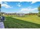 A grassy backyard with a pond provides a serene view from the patio and blends nature with modern living at 8979 Milestone Dr, Sarasota, FL 34238
