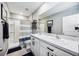 Well-lit bathroom features dual sinks, a large mirror, and a shower with a decorative curtain at 8979 Milestone Dr, Sarasota, FL 34238
