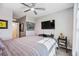 Comfortable bedroom featuring a ceiling fan, mounted TV, and a stylish gray and white patterned bedspread at 8979 Milestone Dr, Sarasota, FL 34238