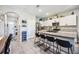 Open kitchen features a large island with seating and granite countertops with stainless steel appliances and white cabinets at 8979 Milestone Dr, Sarasota, FL 34238