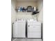Functional laundry room with washer, dryer, and shelving for storage of cleaning supplies at 8979 Milestone Dr, Sarasota, FL 34238