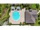 Aerial view of a large community pool with ample seating and lush landscaping, and a nearby clubhouse at 8979 Milestone Dr, Sarasota, FL 34238