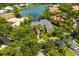 Aerial view of this luxurious home with mature trees, landscaping, and a lake view at 8999 Wildlife Loop, Sarasota, FL 34238