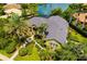 Aerial view of this luxurious home with beautiful landscaping, a lake view, and a brick walkway at 8999 Wildlife Loop, Sarasota, FL 34238