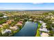Wide aerial view of the neighborhood featuring well-maintained homes along the lake with mature landscaping at 8999 Wildlife Loop, Sarasota, FL 34238