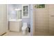 Bathroom featuring a tiled walk-in shower, commode, and framed mirror at 8999 Wildlife Loop, Sarasota, FL 34238