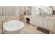 Elegant bathroom featuring a freestanding tub, glass block shower, and and vanities at 8999 Wildlife Loop, Sarasota, FL 34238