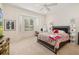 Bright bedroom with a bay window, carpet flooring, and a modern ceiling fan at 8999 Wildlife Loop, Sarasota, FL 34238